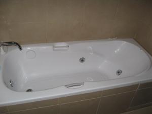 a white bath tub in a tiled bathroom at Bahiaxdia Paraguay in Bahía Blanca