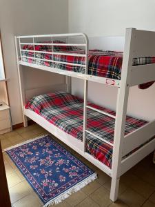 two bunk beds in a room with a rug at Castori due in Prazzo +19 photos