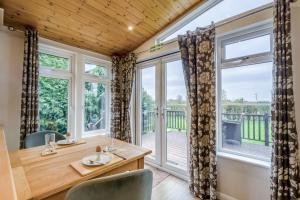 a dining room with a table and chairs and large windows at Field View 1 bed-No Pets- Walnut in Eye