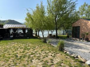 a house on the shore of a lake with trees at Anchor Boutique- Clisura Dunării in Liborajdea