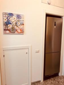 eine Küche mit Kühlschrank und einem Gemälde an der Wand in der Unterkunft mistral'25 in Cefalú