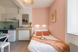 a small bedroom with a bed and a kitchen at Le Colibri in Foix