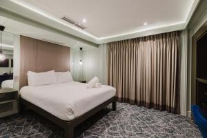 a bedroom with a large white bed and a window at The Lancaster Hotel in London