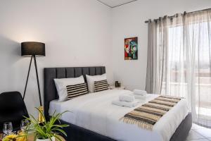 a bedroom with a large white bed with white pillows at Studio Scirocco in Tympáki