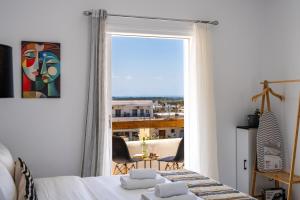 a bedroom with a bed and a large window at Studio Scirocco in Tympáki