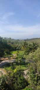 a view of a field with trees and a river at Casa de praia castelhanos in Anchieta +3 photos