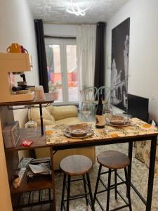 ein Wohnzimmer mit einem Tisch, Gläsern und Stühlen in der Unterkunft mistral'25 in Cefalú