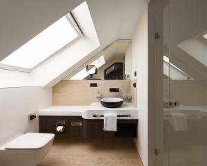a bathroom with a sink and a toilet and a skylight at Limehome Düsseldorf Pionierstraße in Düsseldorf