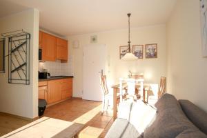 a kitchen and dining room with a couch and a table at Ostseewelle Wohnung 24 in Kühlungsborn +14 photos