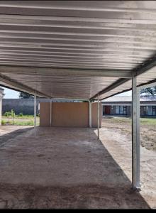 an empty parking lot with a large metal roof at Mkhuzewamanzi Accommodation in Mkuze