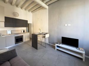 a living room with a couch and a tv and a kitchen at René Apartments in Salsomaggiore Terme +3 photos