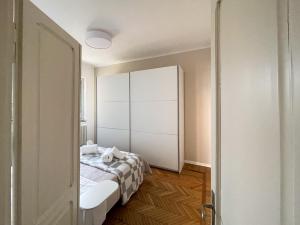 a bedroom with a bed and a white cabinet at René Apartments in Salsomaggiore Terme
