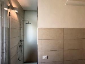 a bathroom with a shower with a glass door at René Apartments in Salsomaggiore Terme