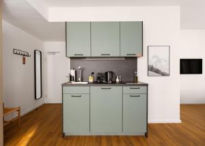a kitchen with white cabinets and a counter top at Limehome Düsseldorf Pionierstraße in Düsseldorf