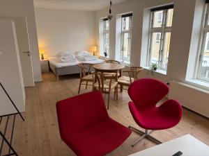 a living room with red chairs and a table at Slotsgaarden ved Hesten in Randers