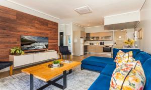 a living room with a blue couch and a table at The Gallery 204 Luxury Apartment in Knysna