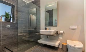 a bathroom with a sink and a glass shower at The Gallery 204 Luxury Apartment in Knysna +27 photos