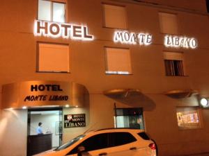 un hotel con un coche aparcado delante de él en Hotel Monte Libano en Paranaguá