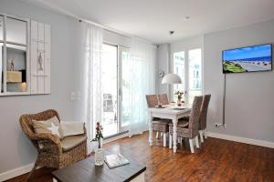 a living room with a dining room table and chairs at Villa Seeadler Wohnung 07 in Börgerende-Rethwisch +10 photos