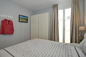 a bedroom with a white bed and a cabinet at Villa Seeadler Wohnung 07 in Börgerende-Rethwisch