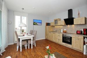 a kitchen with a table and a dining room at Villa Seeadler Wohnung 07 in Börgerende-Rethwisch
