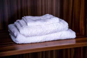 a stack of white towels sitting on a wooden shelf at Ivory's Nest in Accra +29 photos