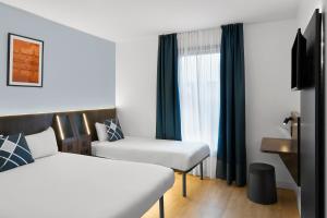 a hotel room with a bed and a chair at Four Points Flex by Sheraton Madrid Atocha in Madrid +19 photos