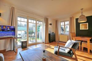 a living room with a television and a table at Villa Seepferdchen Wohnung 01 in Kühlungsborn