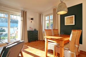 a dining room with a wooden table and chairs at Villa Seepferdchen Wohnung 01 in Kühlungsborn