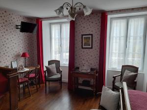 a bedroom with red curtains and a table and chairs at Chambres d'Hôtes et Table d'Hôtes- Valentine 44 in Sainte-Mère-Église