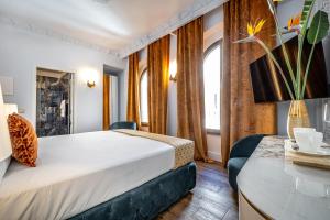 a hotel room with a bed and a table at Gold Artè Collection in Florence
