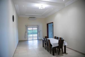 a dining room with a white table and chairs at Ivory's Nest in Accra