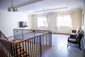 a living room with a staircase and chairs in a room at Ivory's Nest in Accra