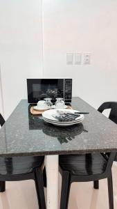 a table with a plate and a microwave on it at Ed Flat Valdeliza Pio in Teresina