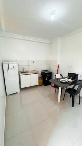 a kitchen with a table and a refrigerator at Ed Flat Valdeliza Pio in Teresina