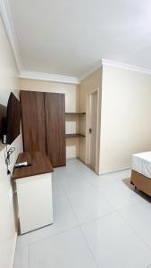 a bedroom with a bed and a desk and a tv at Ed Flat Valdeliza Pio in Teresina +4 photos