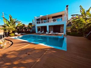 a villa with a swimming pool in front of a house at Rastoni Sea View Studio with Shared Pool in Melíssion