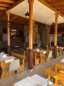 a restaurant with wooden tables and chairs and a fireplace at Motel San Marino in Kuru-Cheshme