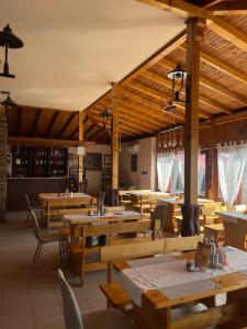 an empty restaurant with wooden tables and chairs at Motel San Marino in Kuru-Cheshme