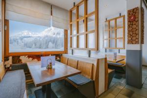 a room with a table and a window with a mountain at Hotel Relais Alpin in Les Mosses