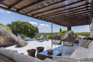 a patio with a couch and chairs and a table at Monte Velho Equo-Resort in Arraiolos