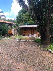 a house with a palm tree in front of it at Chalé Medieval in Brumadinho