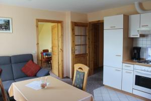 a kitchen and a living room with a couch and a table at Steenshof in Klötzin