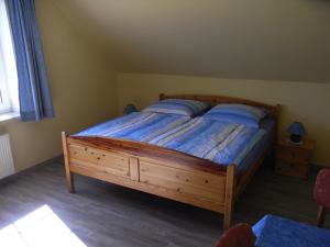 a bedroom with a large wooden bed with blue sheets at Steenshof in Klötzin