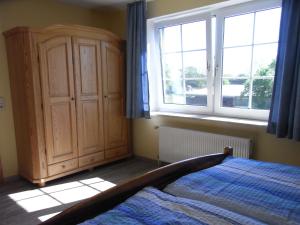 a bedroom with a bed and a large window at Steenshof in Klötzin