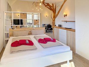 a bedroom with a white bed with red towels on it at Eichengrund Baum 7 in Burg