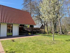 a tree in a yard next to a house at Eichengrund Baum 7 in Burg