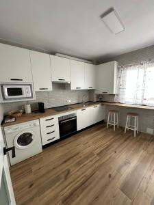 a kitchen with white cabinets and a washer at Apartamento La Celestina in La Puebla de Montalbán