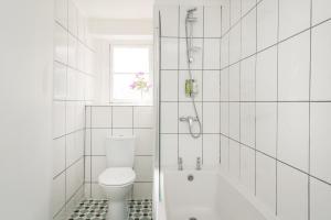 a white bathroom with a toilet and a bath tub at The Washington in Bristol +16 photos