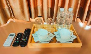 a tray with cups and bottles of water and a remote control at ZKB Twins Hotel in General Santos
